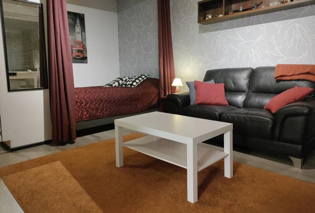 a living room with a couch and a coffee table at Kodikas yksiö keskustassa omalla autopaikalla in Joensuu