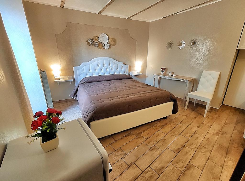 a bedroom with a bed and two tables and a chair at B&B Duca Orsini in Gravina in Puglia