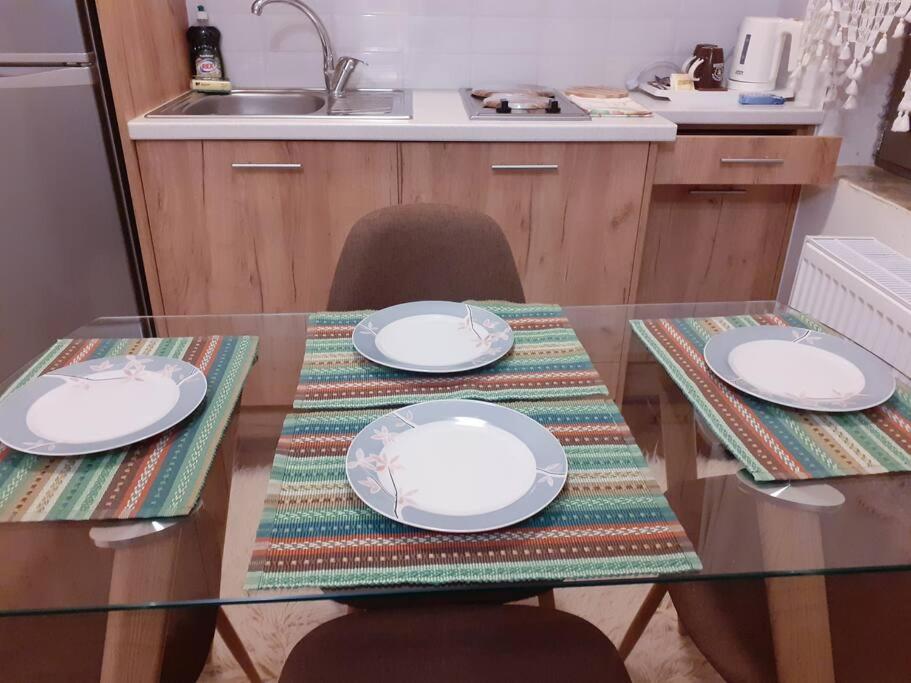 a glass table with plates on it in a kitchen at Christos Home in Pramanta