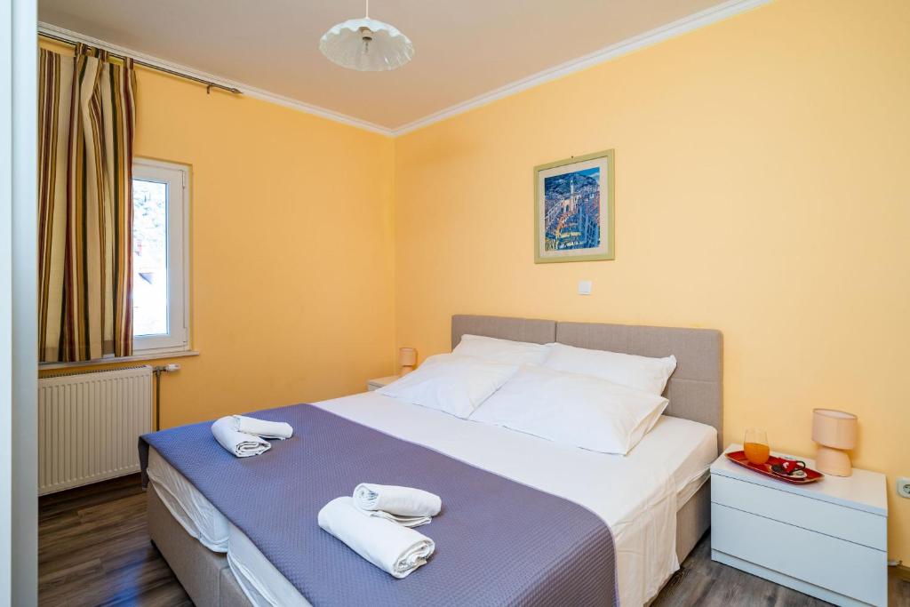 a bedroom with a bed with towels on it at Apartmani Niki ZVEKOVICA in Cavtat