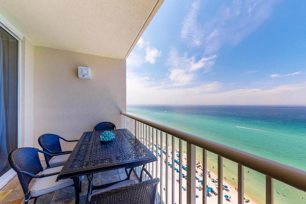 a balcony with a table and chairs and the ocean at Majestic Beach Resort Tower 2- 1805 in Panama City Beach