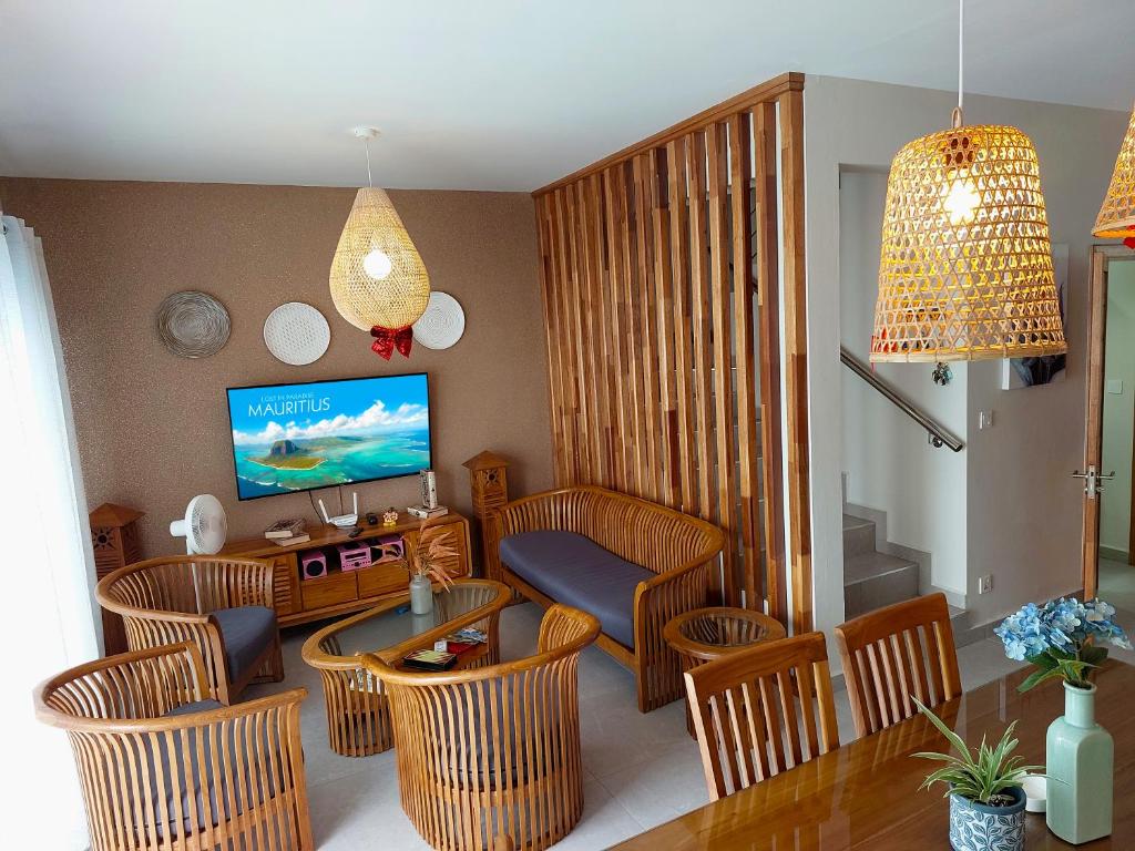 a living room with a couch and chairs and a television at Golden Square Villa & Private Pool in Flic-en-Flac