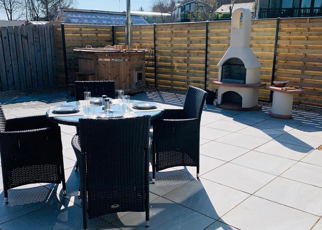 a patio with a table and chairs and a pizza oven at Springhouse Country Park in Slaley