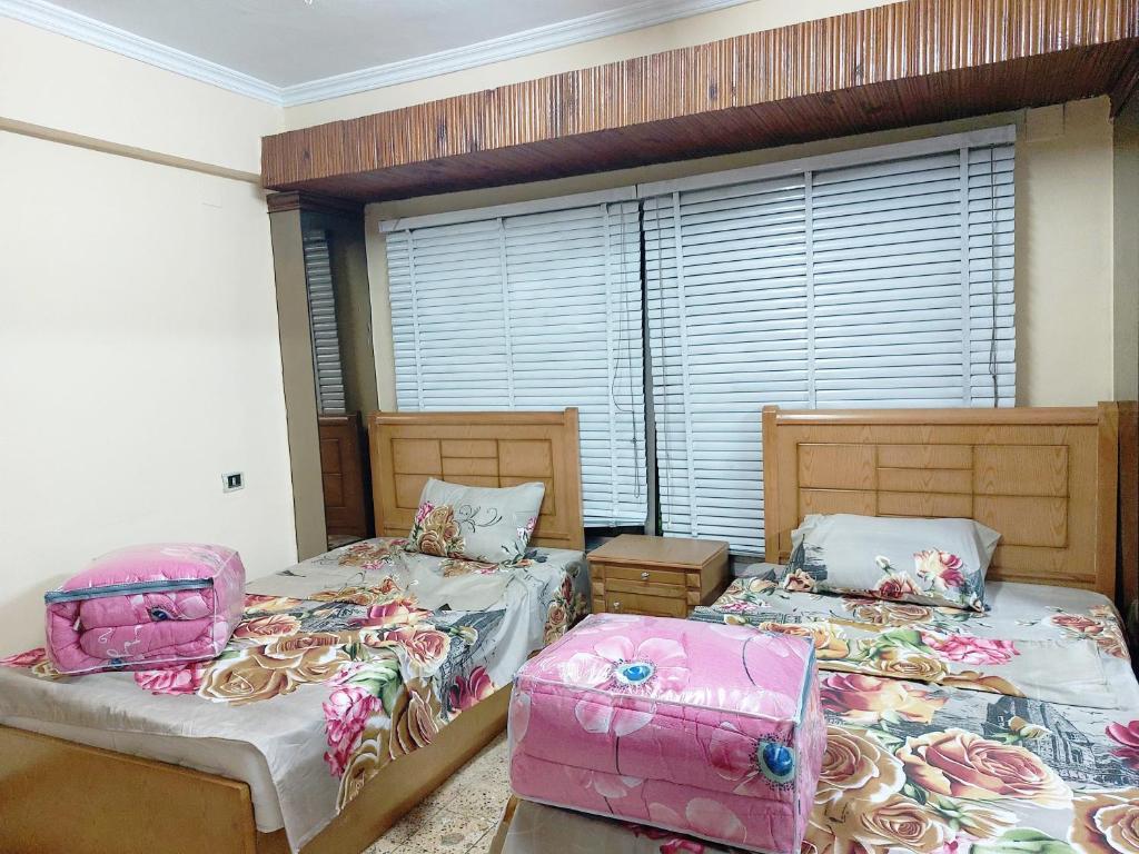 two twin beds in a room with a window at شقة فندقية بجوار محطة مترو الدقي in Cairo