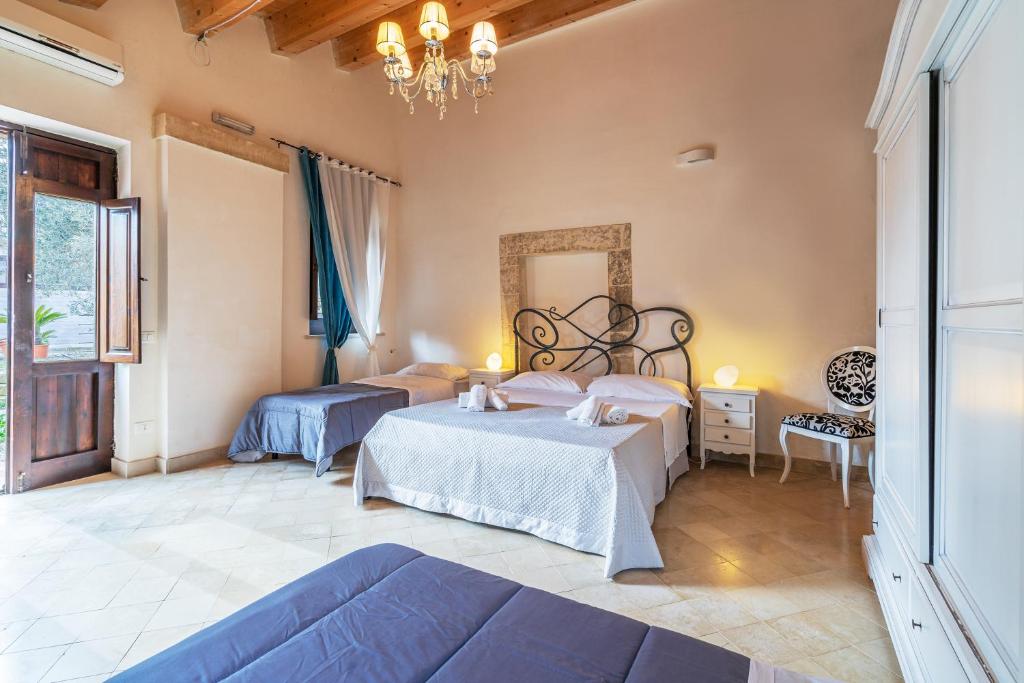 a bedroom with two beds and a chandelier at Agriturismo Kypeiros in Noto