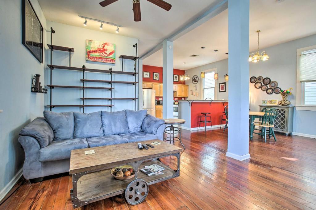 a living room with a blue couch and a table at Charming NOLA Home 5 Miles to Bourbon Street! in New Orleans