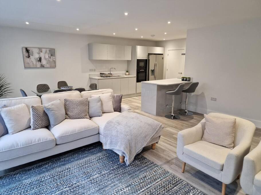 a living room with a couch and two chairs and a kitchen at Luxury 3 Bed House, Parking, Garden and 2 Office desks 2 in Southbourne