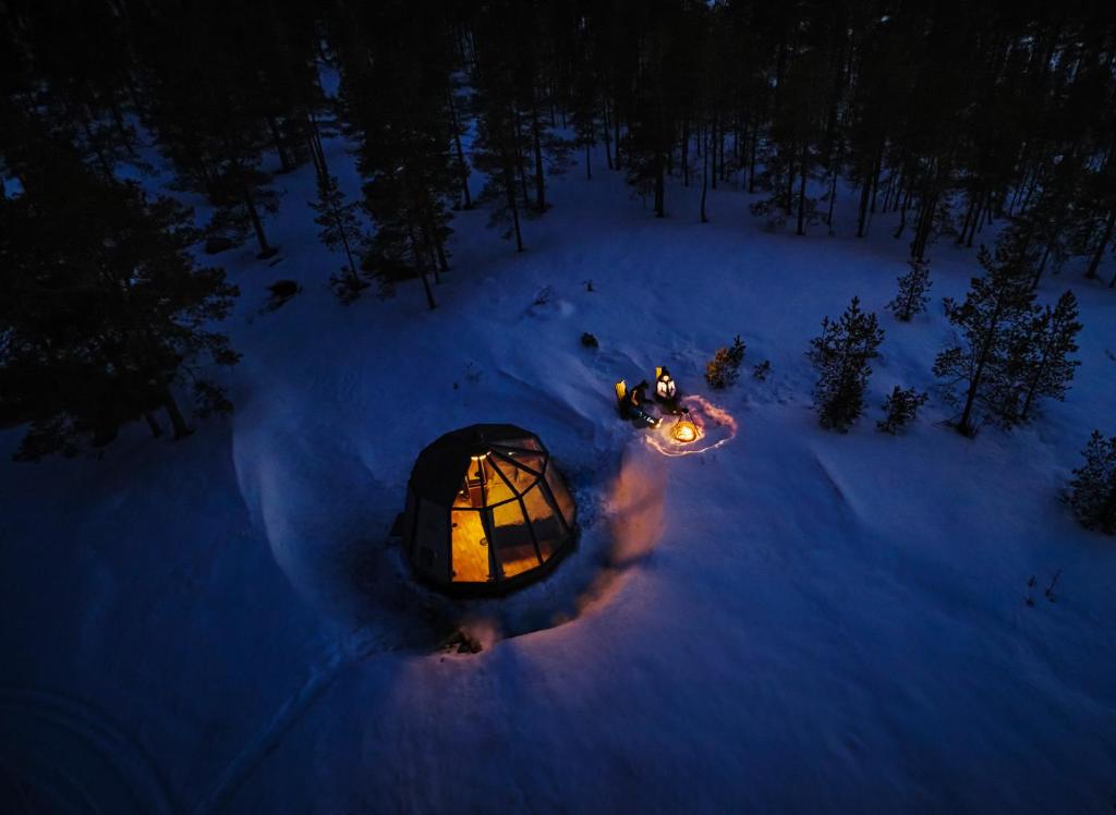 una vista aérea de una tienda en la cúpula en la nieve por la noche en Northern Lodges en Piteå