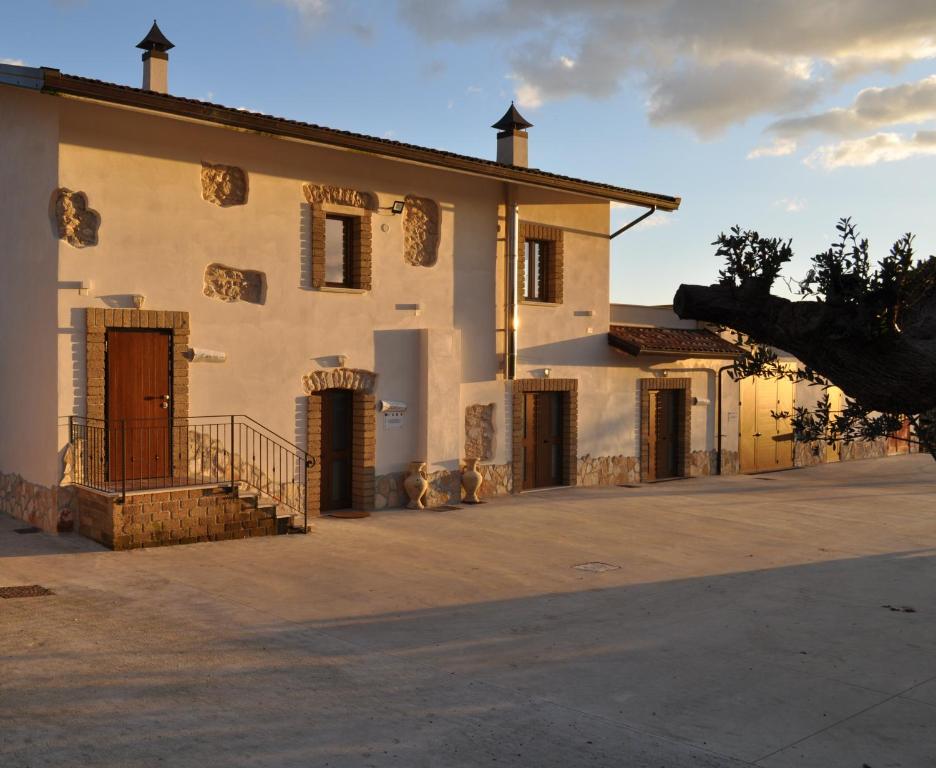 - un grand bâtiment blanc avec des portes et une terrasse couverte dans l'établissement Terrae Tiferni, à Gioia Sannitica