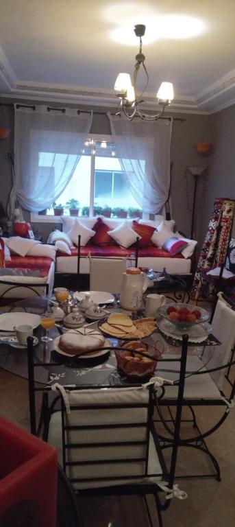 una sala de estar con una mesa con platos de comida en Chez Axia Tanger, en Tánger