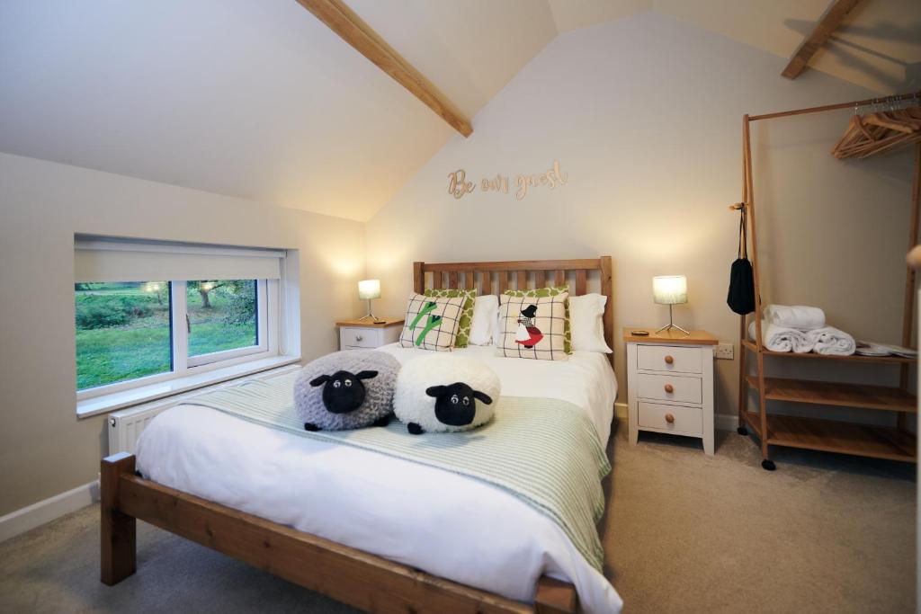 um quarto com dois bichos de peluche numa cama em Carreglwyd em Llandeilo