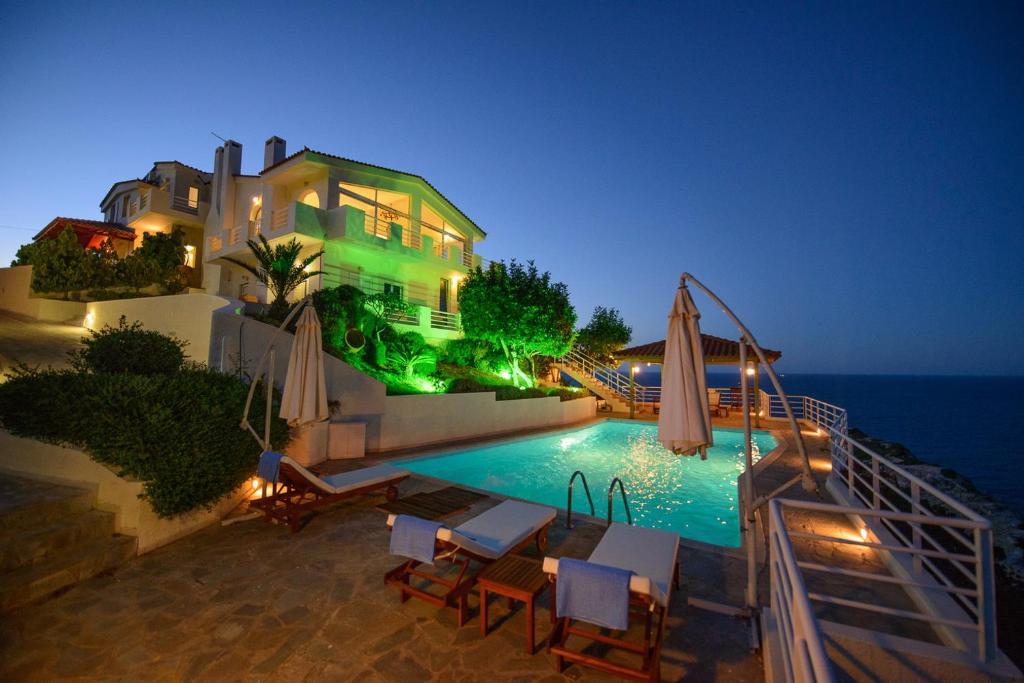 a house with a swimming pool at night at Andromeda in Agia Pelagia