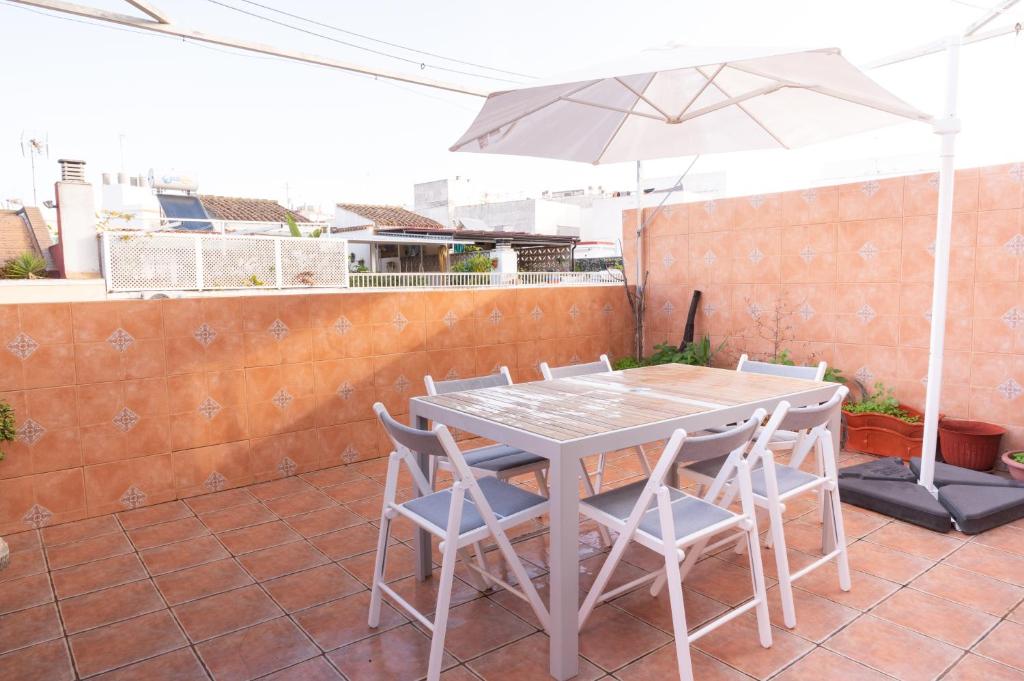 einen Tisch und Stühle mit Sonnenschirm auf einer Terrasse in der Unterkunft CASA SALMÓN in Cádiz