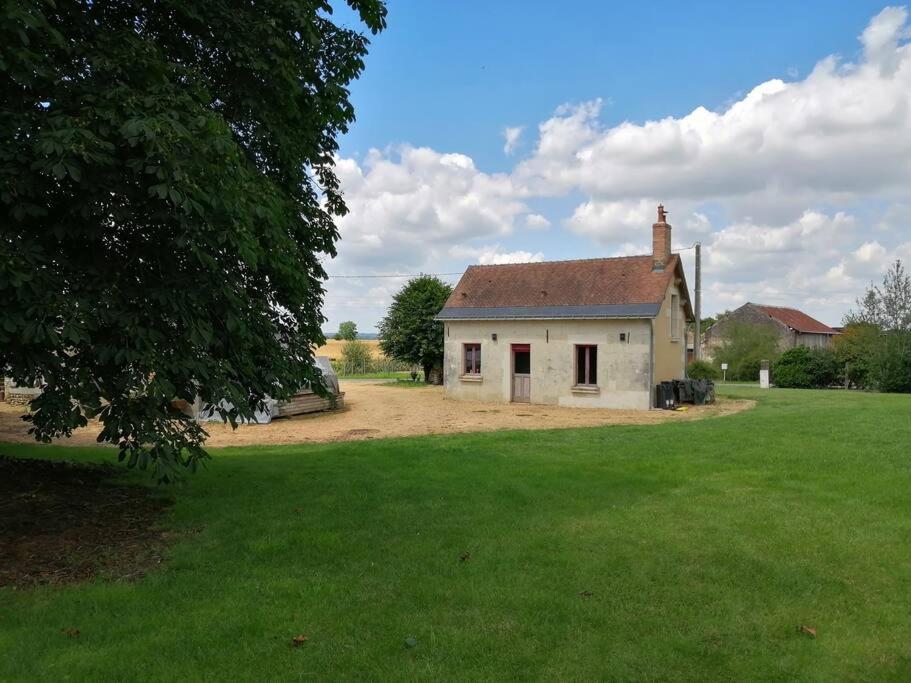 an old white house in a field of grass at Maison a la campagne in Saint-Pierre-de-Chevillé