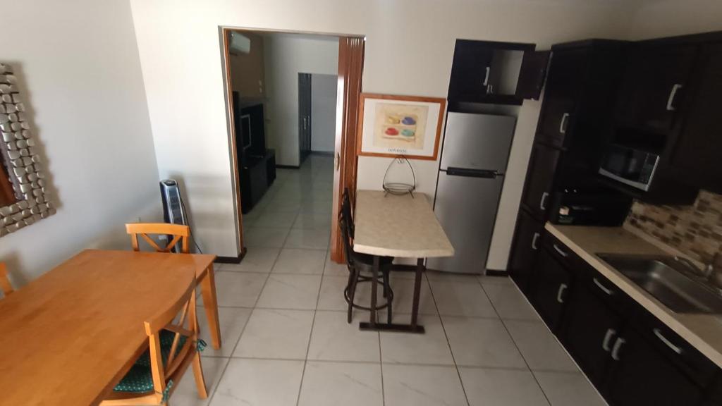 a small kitchen with a table and a refrigerator at Suites Entrelagos in Ciudad Obregón