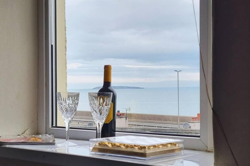 a bottle of wine and two glasses on a window at Seaview cottage North Wales in Penmaen-mawr
