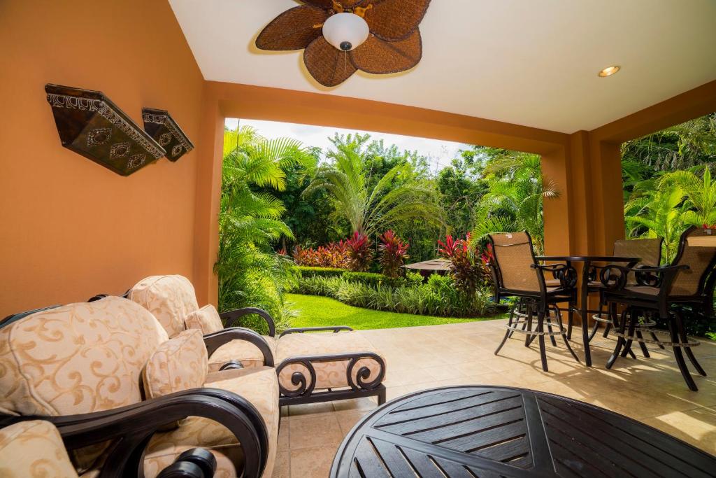 a living room with a ceiling fan and a patio at Los Suenos Resort Veranda 1E by Stay in CR in Herradura