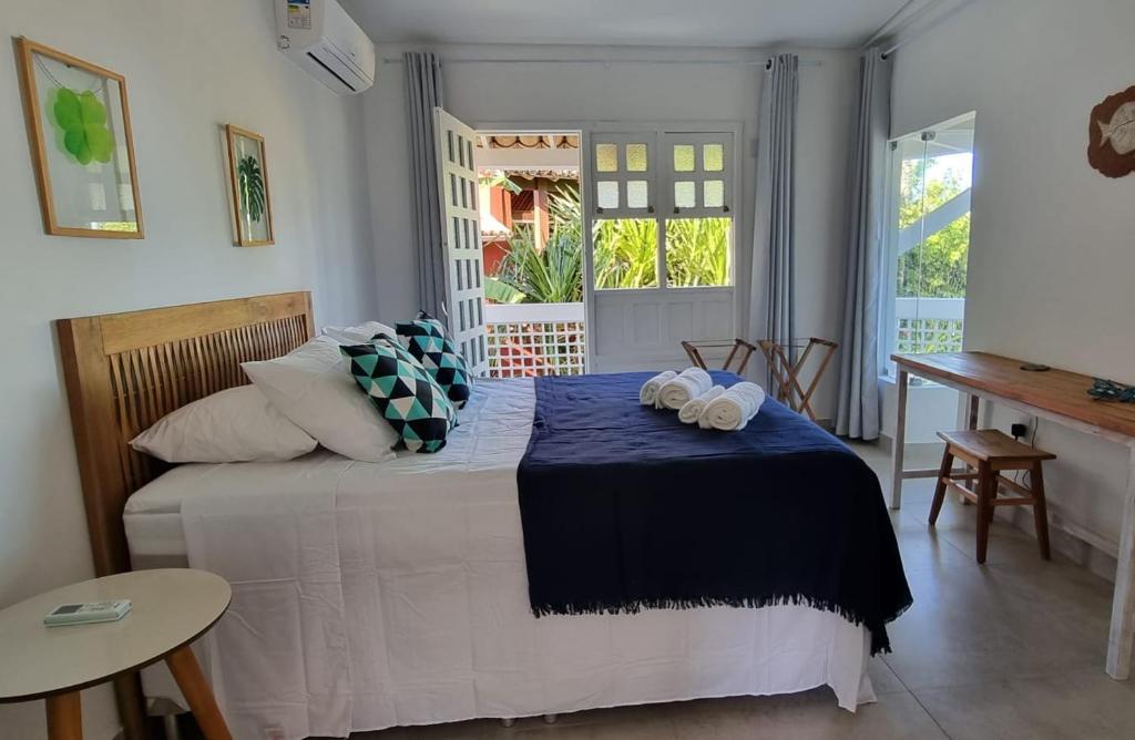 a bedroom with a bed with two towels on it at Vista para o mar Arraial d'Ajuda in Arraial d'Ajuda