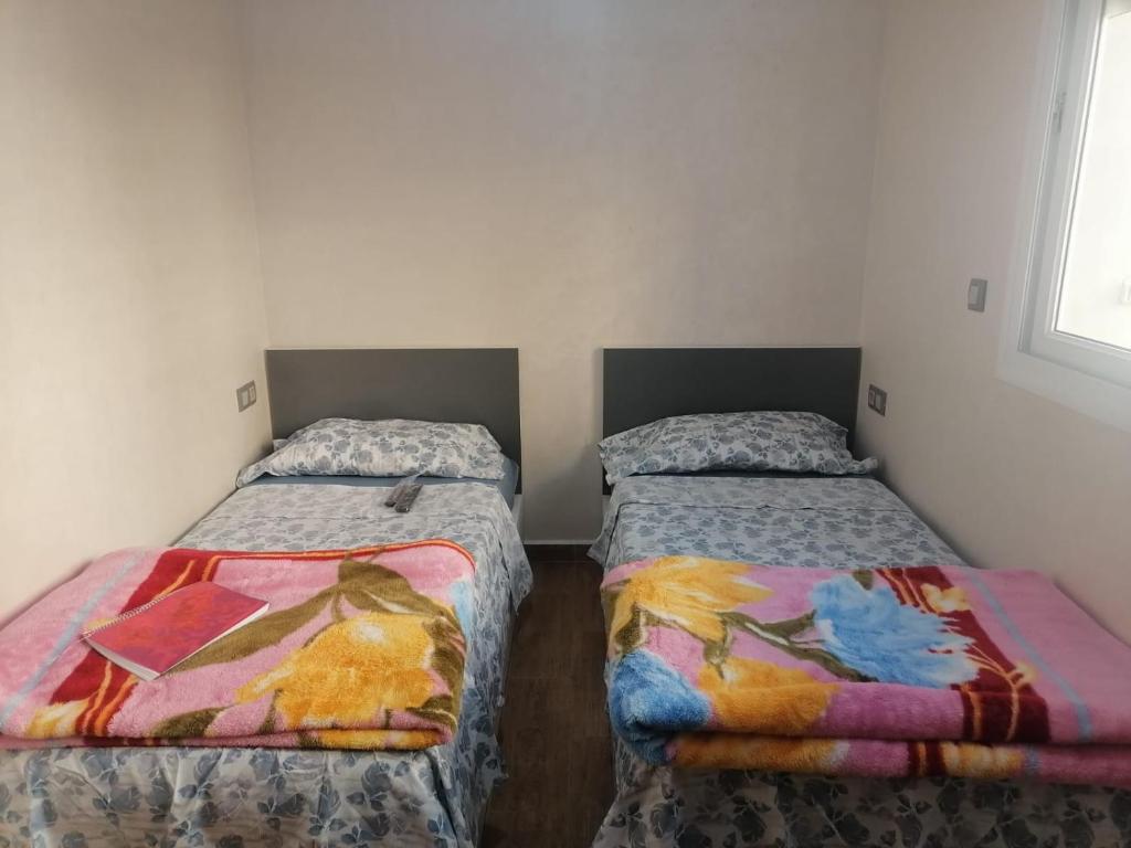 twee bedden in een kleine kamer met bij hay adrar 2 agadir Morocco in Agadir