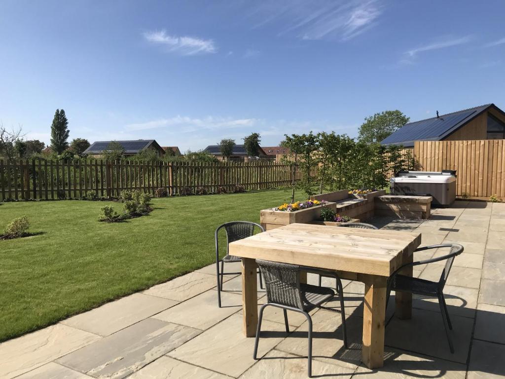 a patio with a table and chairs in a yard at Water Lily Cottage, Ashlin Farm Barns in Lincoln