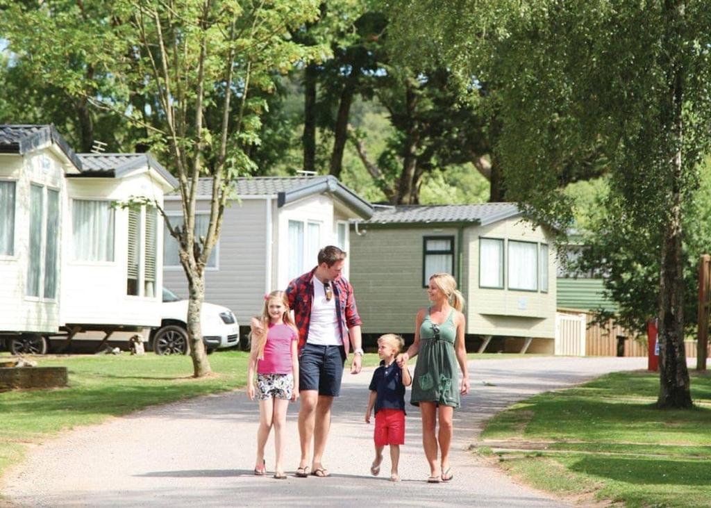 a family walking down a driveway in their home at Castle Brake Holiday Park in Woodbury