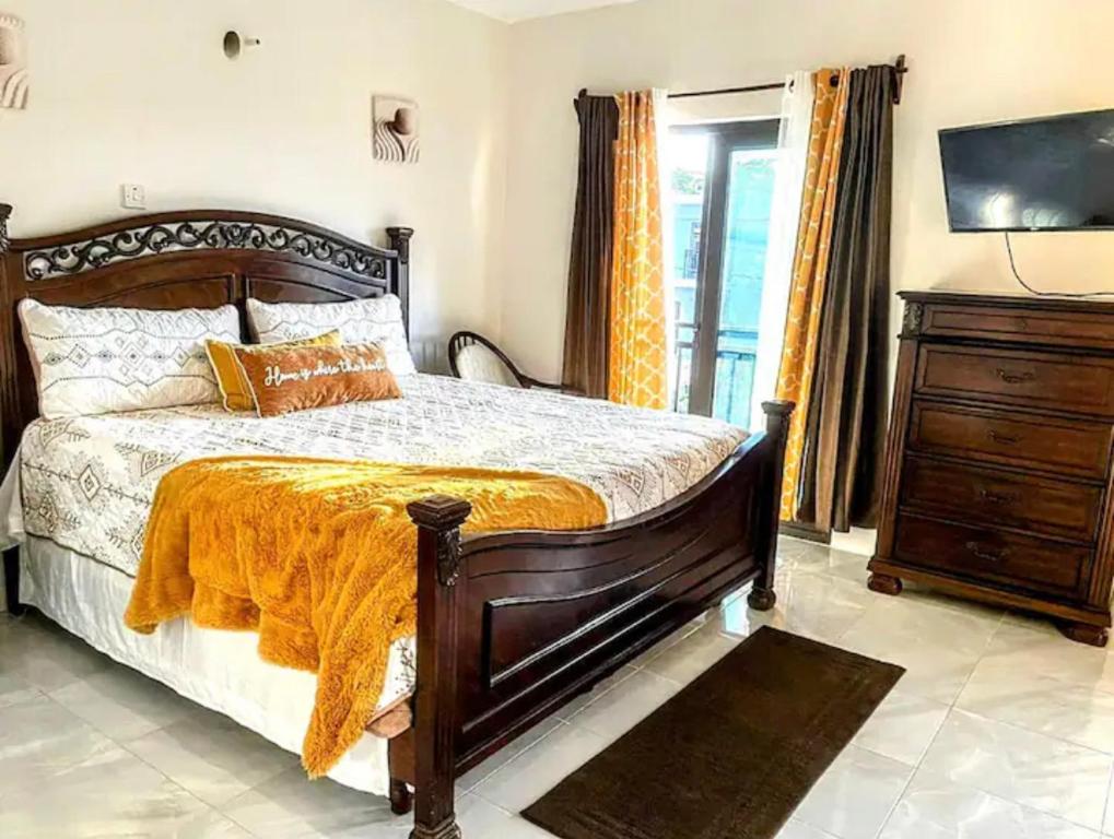 ein Schlafzimmer mit einem Bett mit einer orangefarbenen Decke in der Unterkunft Wynters'Escape-gated 1 or 2 Bedroom w PuertoSecoBeach access in Discovery Bay