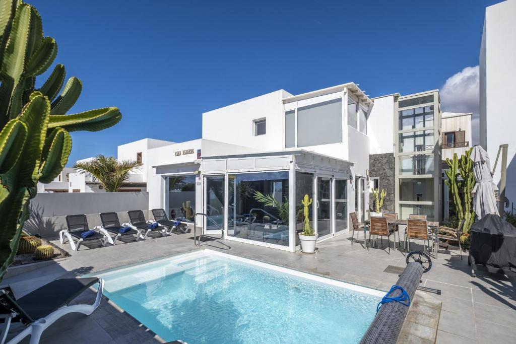 a villa with a swimming pool and a house at Casa Saidera in Playa Blanca
