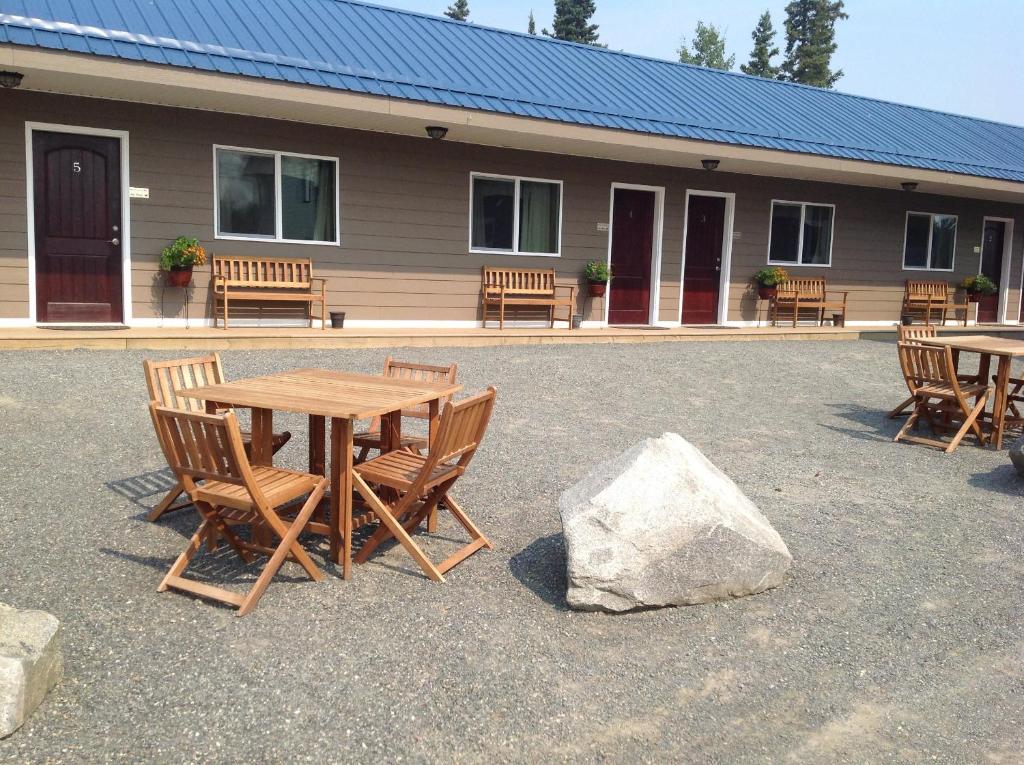 a wooden table and chairs in front of a building at Parkside Inn in Haines Junction