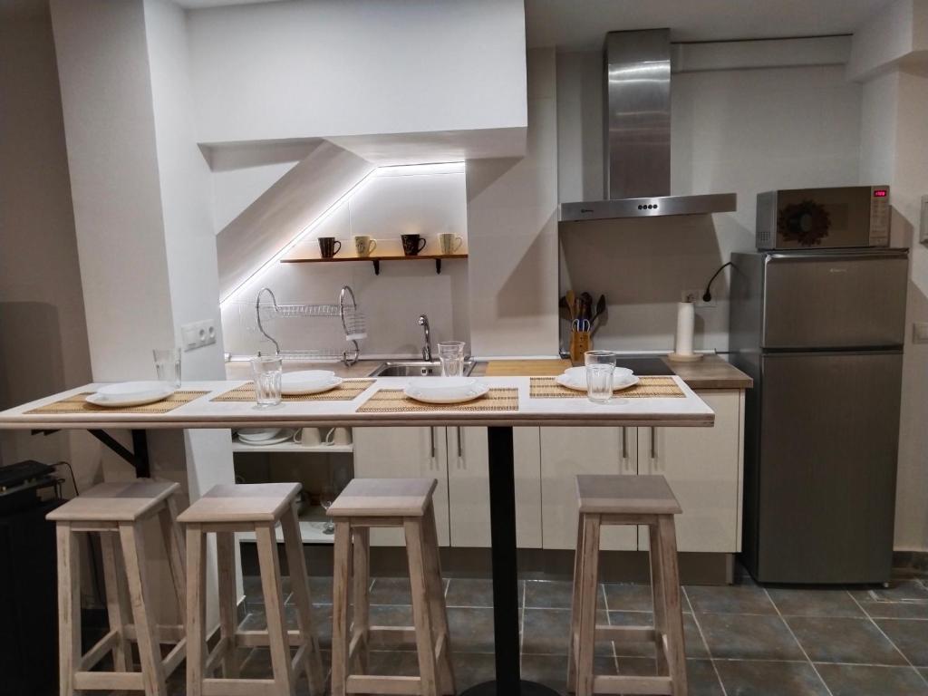 een keuken met een eiland met krukken en een aanrecht bij Acogedor apartamento loft in Alhaurín de la Torre