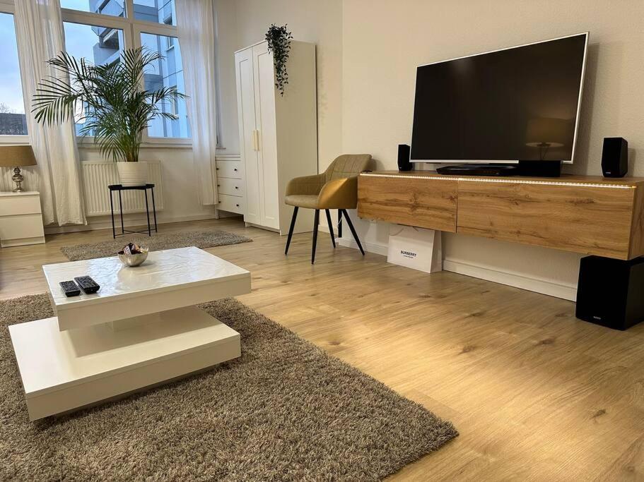 a living room with a large flat screen tv at MORINA Residences in Mainz