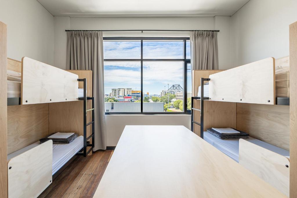 a bedroom with bunk beds and a large window at Bunk Brisbane in Brisbane