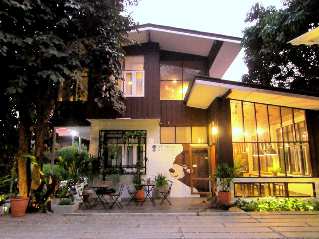 a house with chairs and tables in front of it at Chiang Mai D Hostel in Chiang Mai