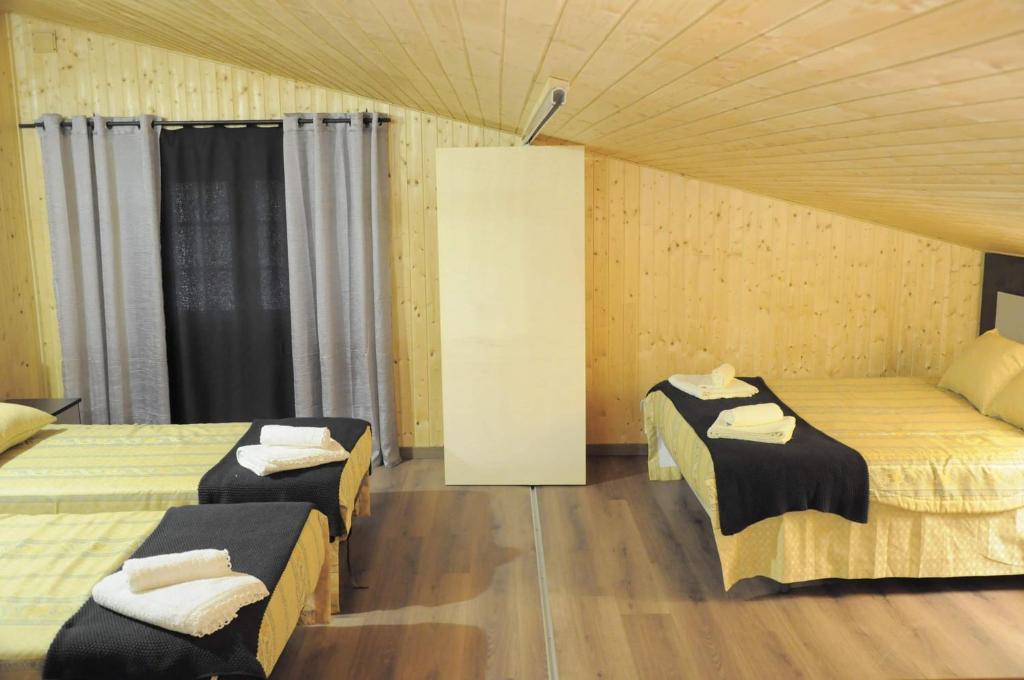 pokój z 2 łóżkami w pokoju z drewnianą podłogą w obiekcie quinta vale da corga w mieście Murça