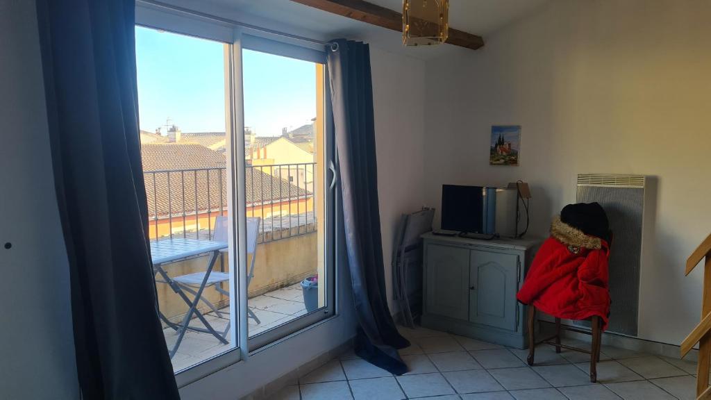 een kamer met een raam met uitzicht op een balkon bij Appartement charmant en Provence in Draguignan