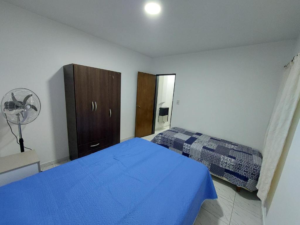 1 dormitorio con cama azul y armario en El descanso en Santa Rosa