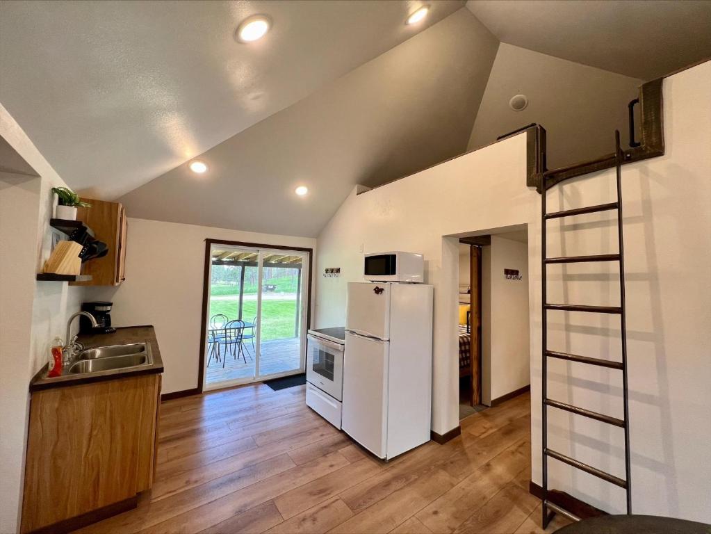 a kitchen with a white refrigerator in a room at Cabin 12 at Horse Creek Resort in Rapid City