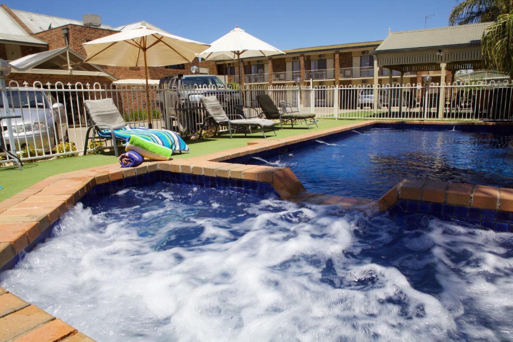 a large swimming pool with blue water in a yard at Paddlewheel Motel in Echuca