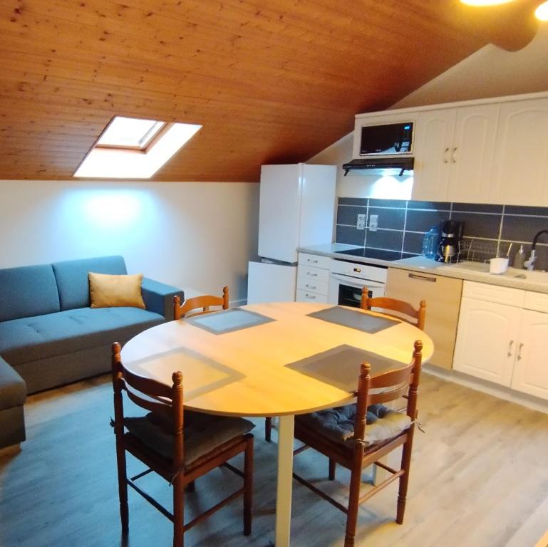 kuchnia oraz stół i krzesła w pokoju w obiekcie Superbe appartement tout confort w mieście Lyaud