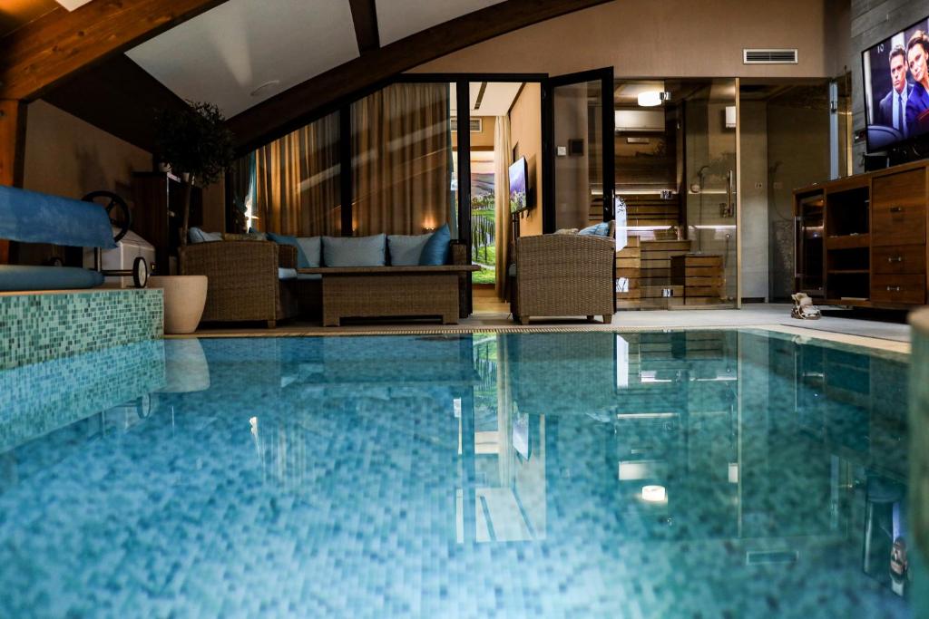 una piscina en una habitación de hotel con sillas en Apartments Marconio Wellness Club en Belgrado