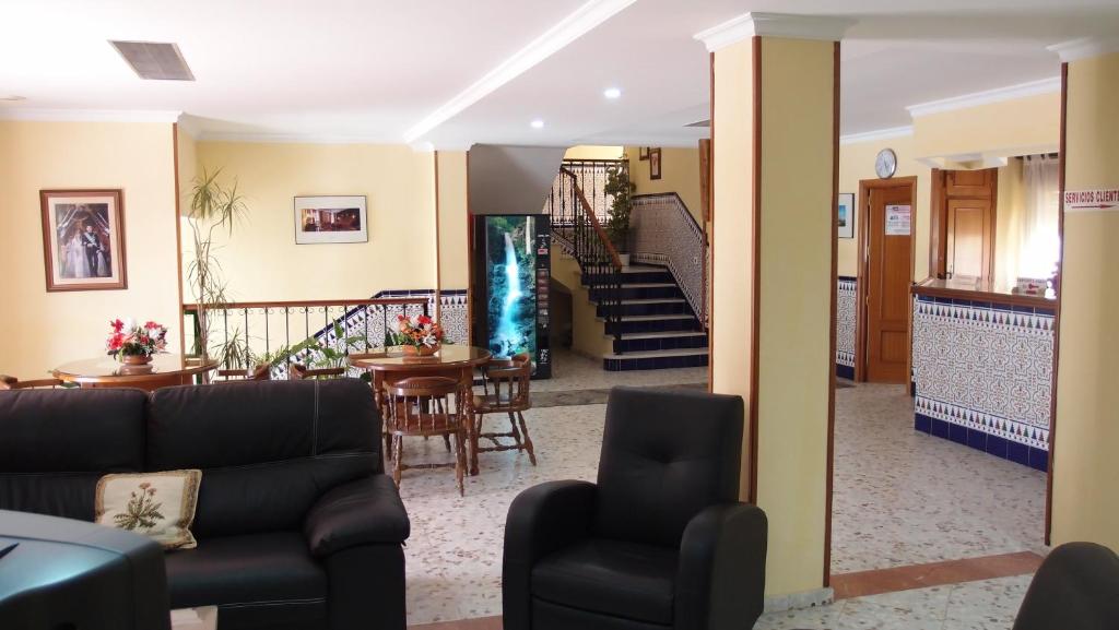 a living room with a couch and chairs and stairs at Hotel Catalán Puerto Real in Puerto Real