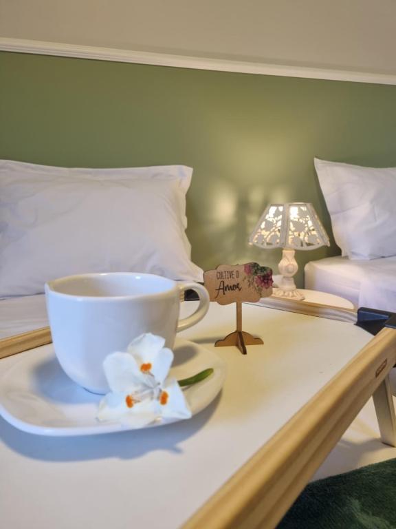 a coffee cup on a tray on a bed at Frieden Haus Pousada in Pomerode