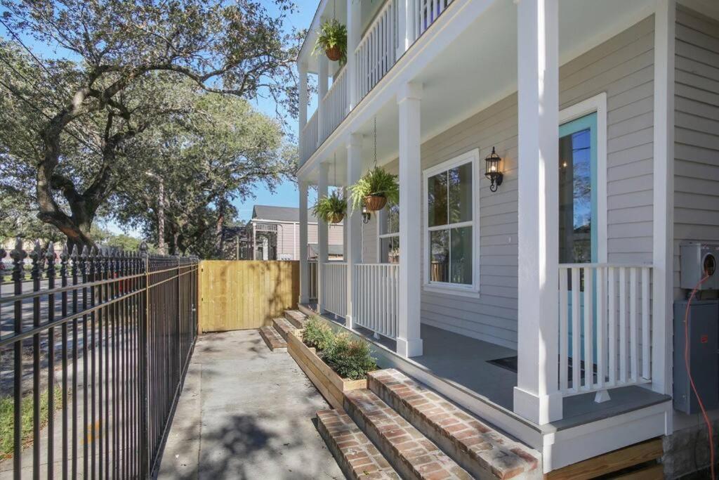 a white house with a porch and a fence at La Belle Veranda Villa- 3QueenBeds/2Baths Sleeps 6-8 in New Orleans