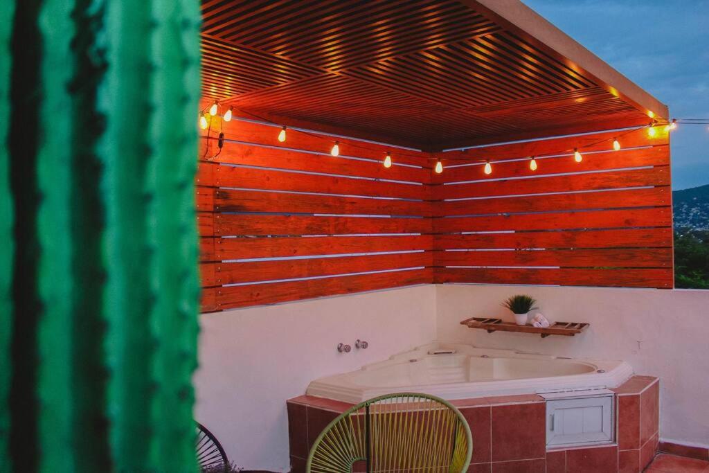 a bathroom with a tub and a wooden wall at "Escapada perfecta" casa con albeca, jacuzzi y roof garden in Tlatenchu