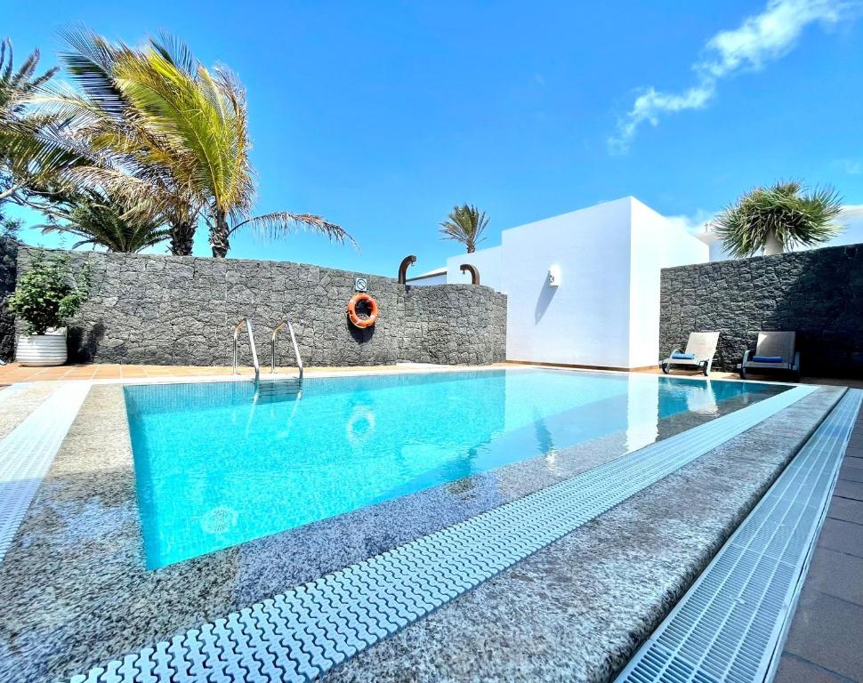 una piscina frente a una villa en Villas Mamma Mia pool heat Private & Jacuzzi, en Playa Blanca