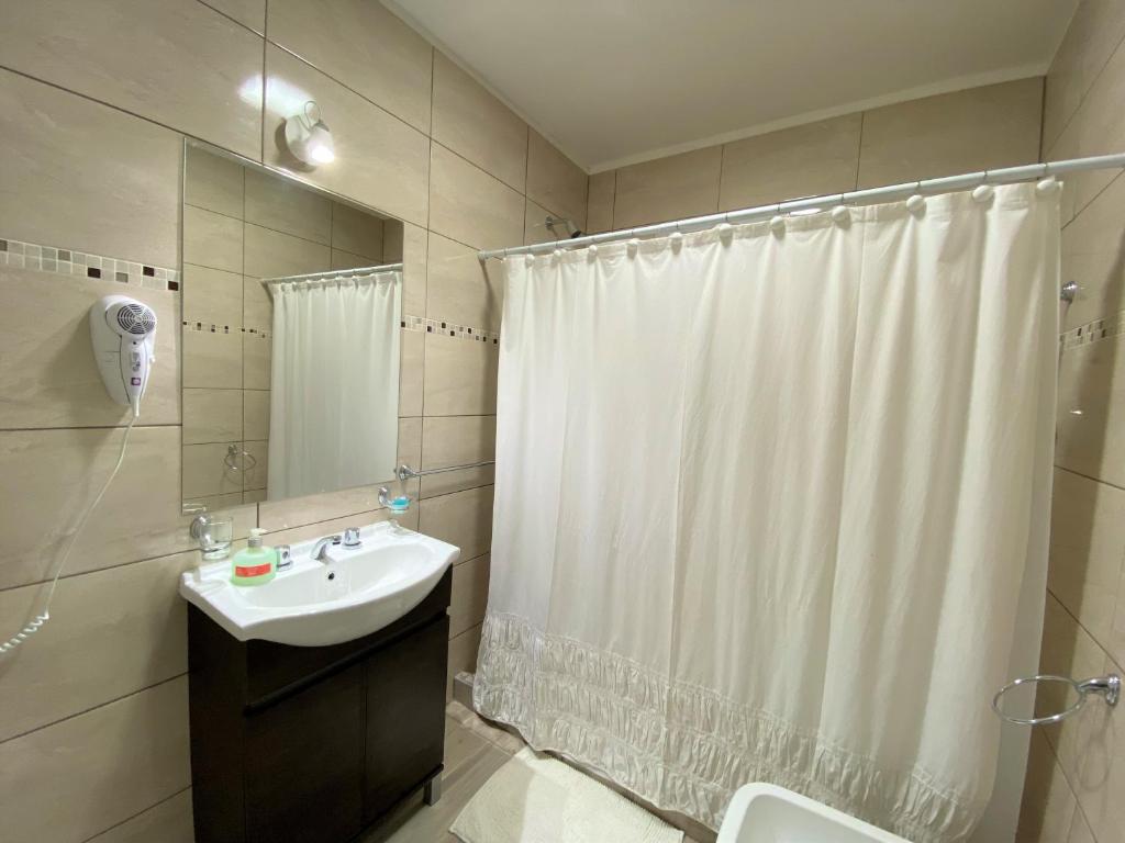 baño con cortina de ducha blanca y lavamanos en Cabaña El Huerto en San Rafael