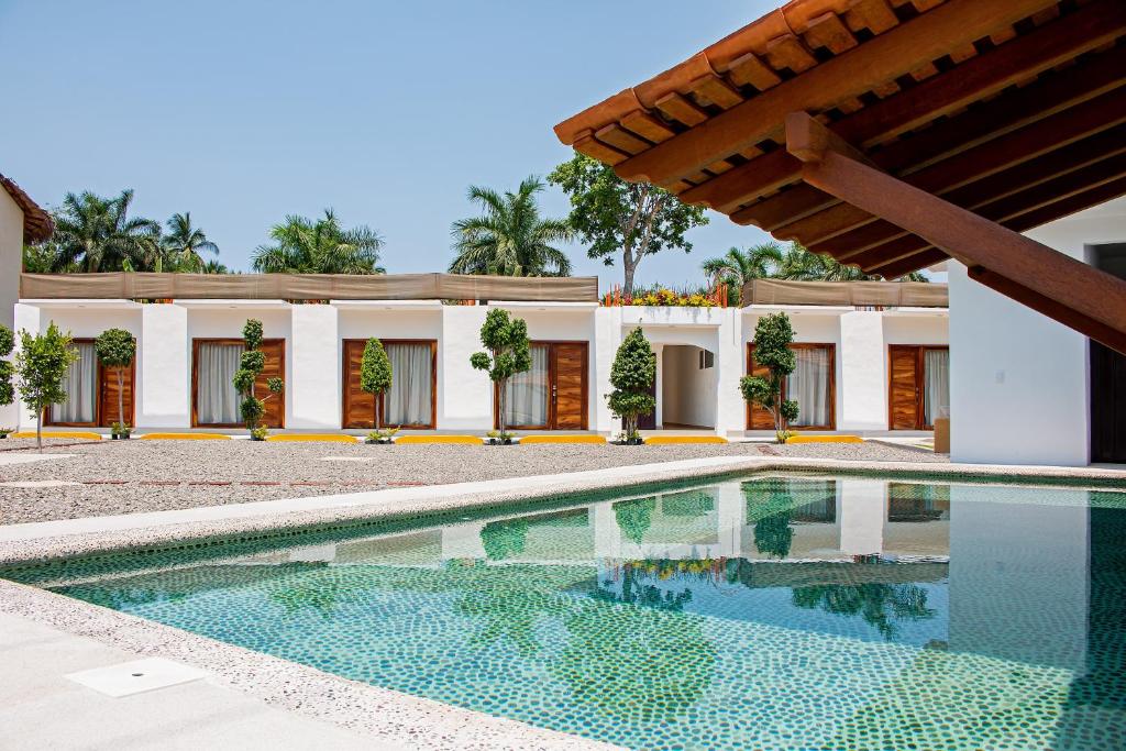 uma piscina em frente a uma casa em HOTEL CASA VICTORIA em Zihuatanejo