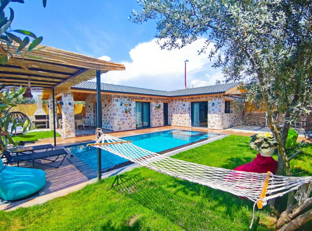 - un hamac dans la cour d'une maison avec piscine dans l'établissement Villa Harmony, à Fethiye