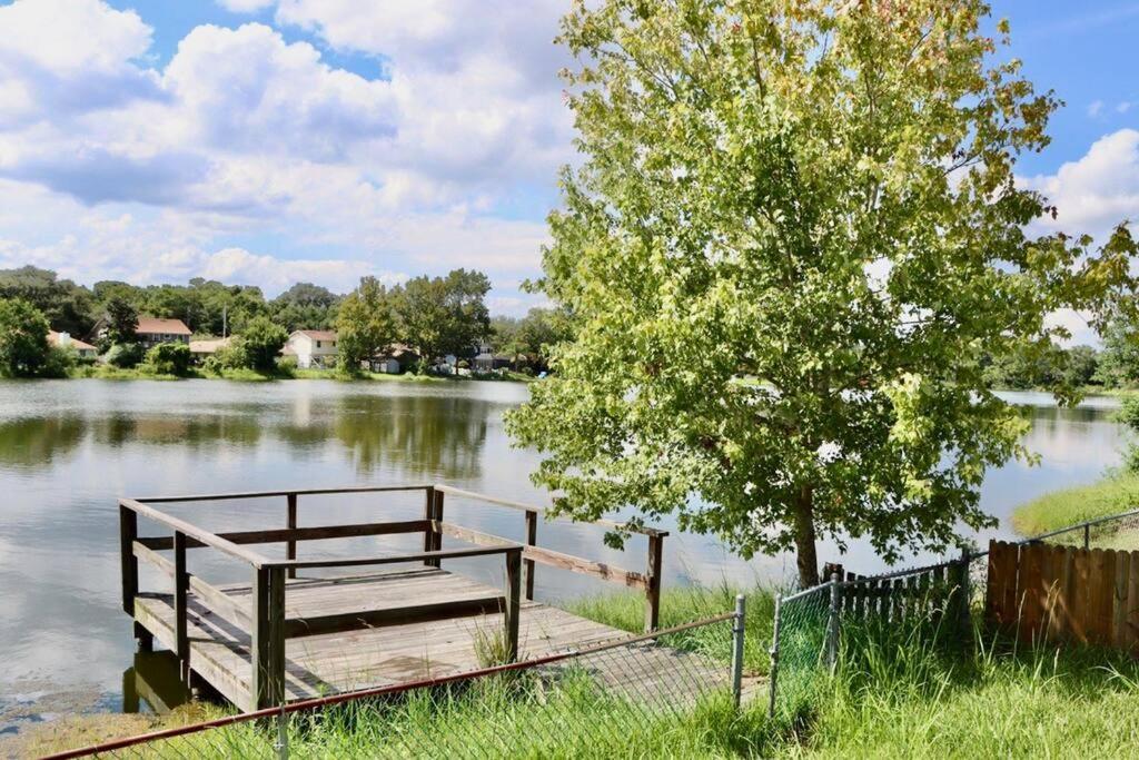 un muelle de madera en un lago con un árbol en Peaceful Family Lake House en Jacksonville