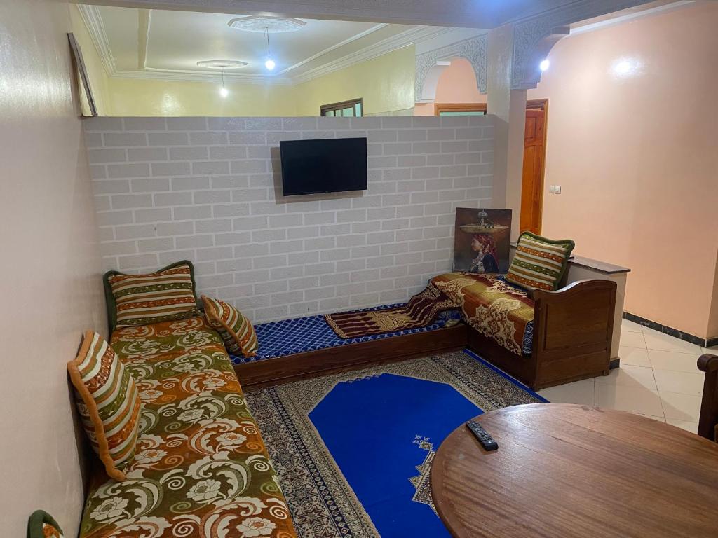 a living room with a couch and a tv at Appartement Ain Asserdoun in Beni Mellal