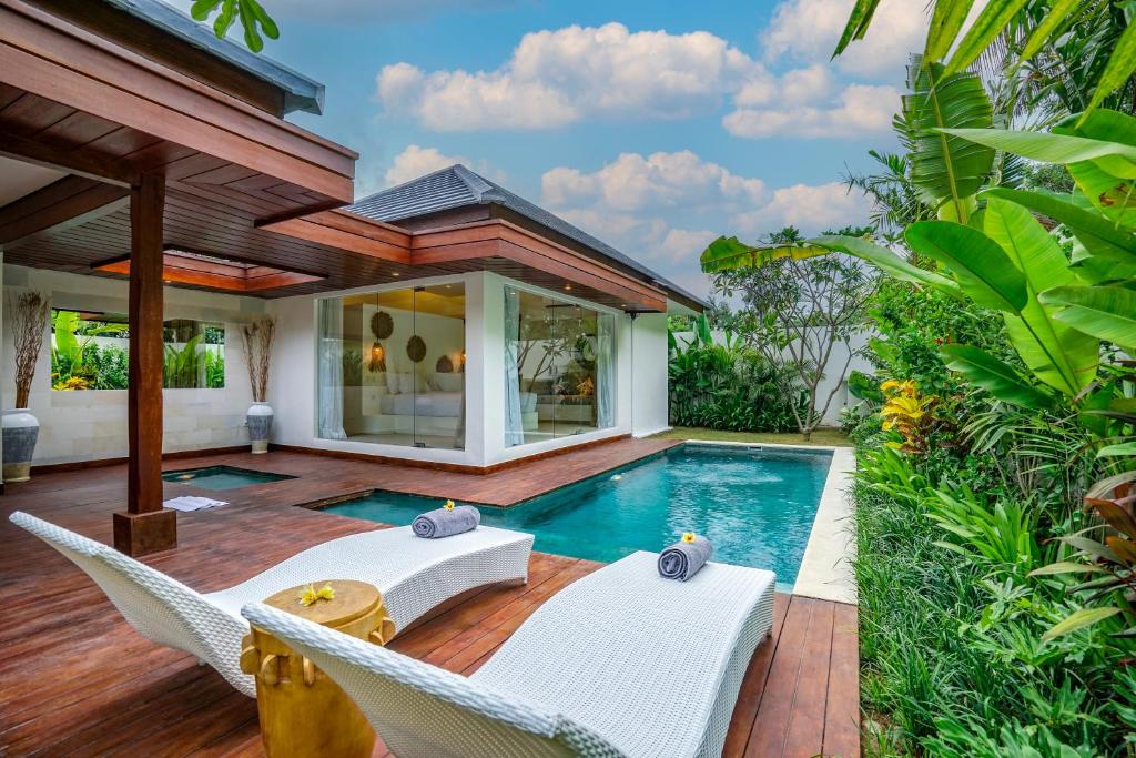 un cortile con piscina, sedie e una casa di Villa Pulau I, 1BR Luxury Private Villa with Pool in North of Bali, Pemuteran, within Walking Distance to a Wild Beach a Buleleng